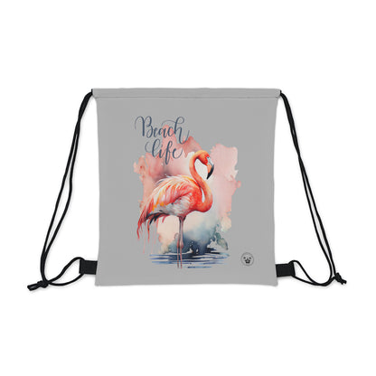 Unleash your wanderlust with our versatile drawstring backpack! Embrace travel with ease and style, flaunting a Beach Life Flamingo graphic with bright color backgrounds. This one is a grey background. Designed for adventurers, it's the perfect blend of practicality and fashion. Get yours today for your next adventure! This is a front view of the backpack.