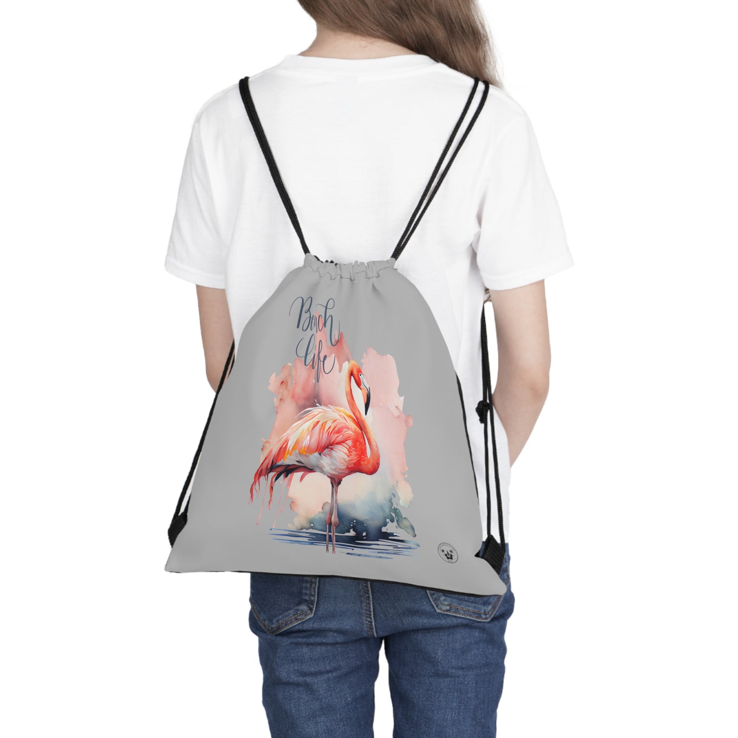 Unleash your wanderlust with our versatile drawstring backpack! Embrace travel with ease and style, flaunting a Beach Life Flamingo graphic with bright color backgrounds. This one is a grey background. Designed for adventurers, it's the perfect blend of practicality and fashion. Get yours today for your next adventure! This is a front view of the backpack on the back of a model.